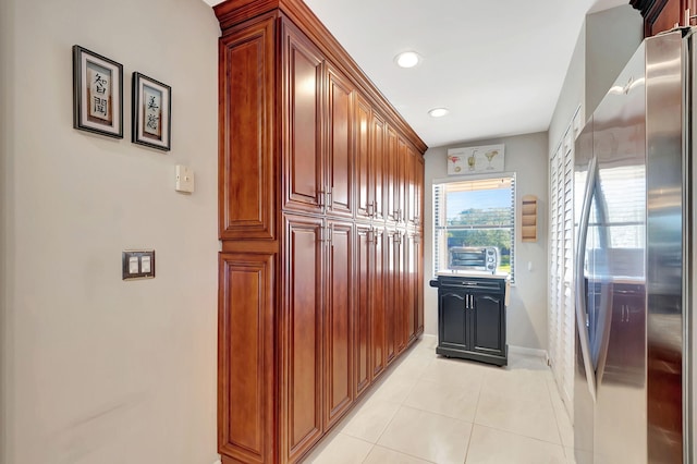 kitchen featuring light tile patterned floors and stainless steel refrigerator