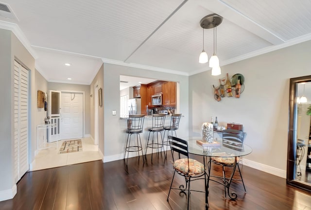 dining area with dark hardwood / wood-style floors and ornamental molding