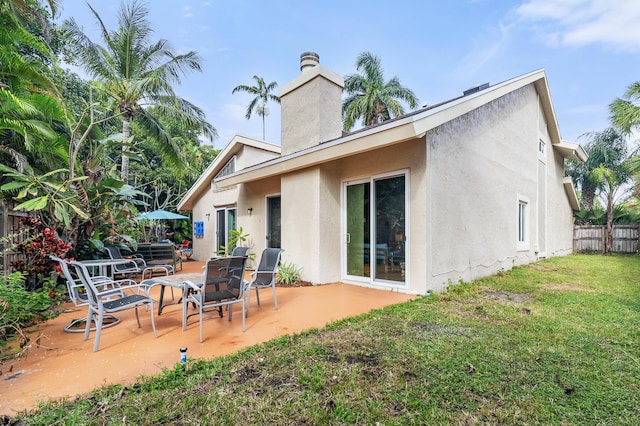 rear view of property featuring a yard and a patio area