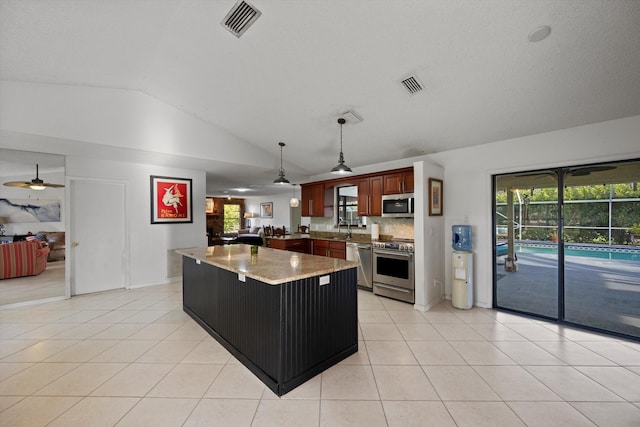 kitchen featuring ceiling fan, decorative light fixtures, lofted ceiling, light tile patterned floors, and appliances with stainless steel finishes