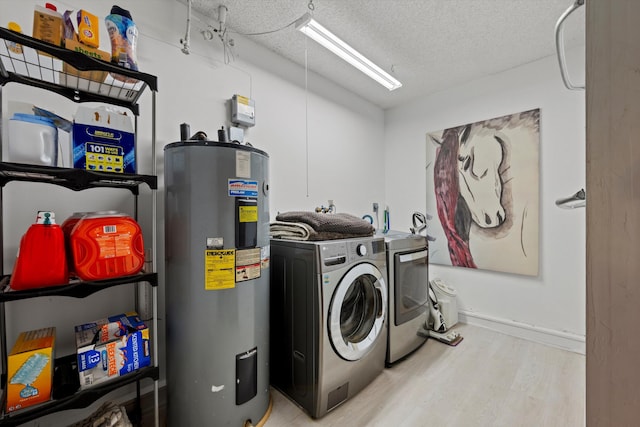 laundry area featuring washer and dryer, light hardwood / wood-style floors, a textured ceiling, and water heater