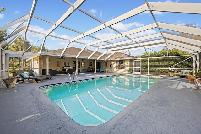 view of pool with outdoor lounge area, a patio area, ceiling fan, and a lanai