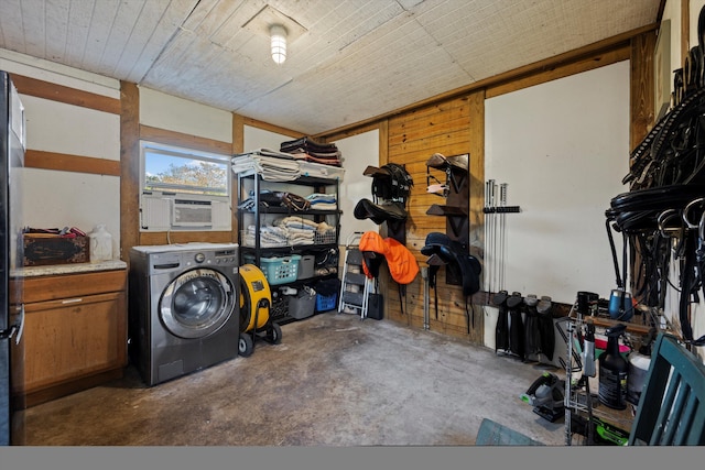 clothes washing area featuring cabinets, cooling unit, washer / dryer, and wooden walls