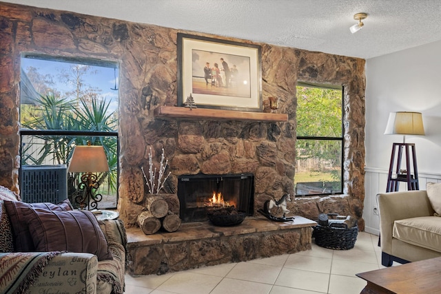 tiled living room featuring a fireplace and a textured ceiling