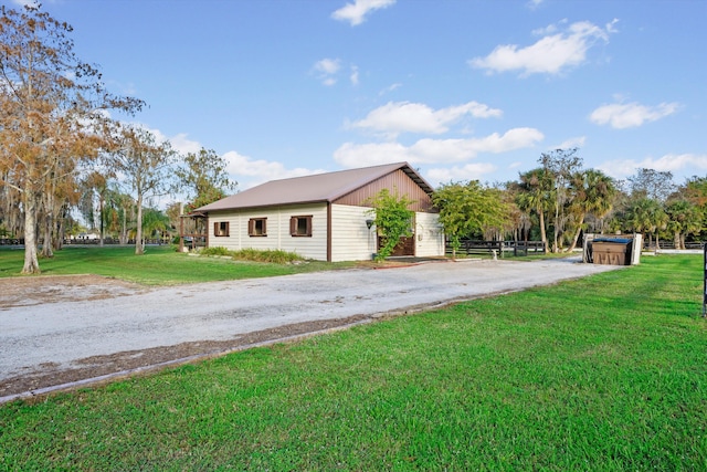 view of property exterior featuring a lawn and an outbuilding