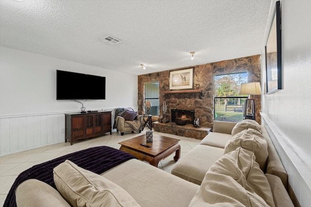 tiled living room featuring a fireplace and a textured ceiling