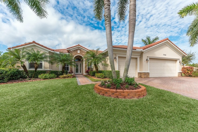 mediterranean / spanish-style home with french doors, a front lawn, and a garage