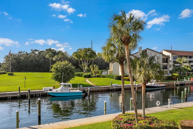 surrounding community with a boat dock, a yard, and a water view