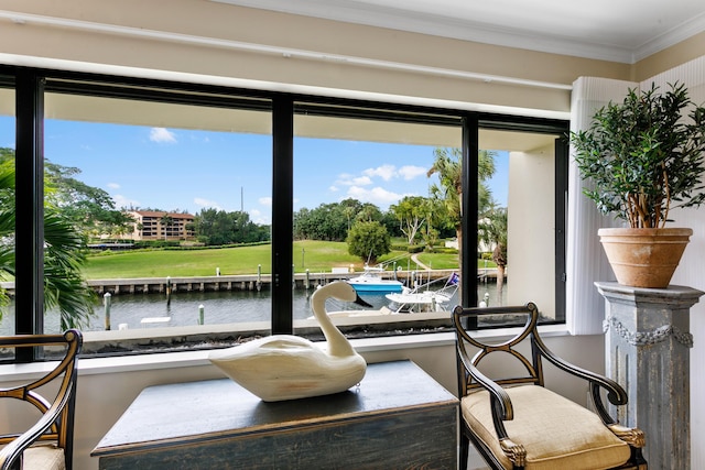 living area with a water view and crown molding