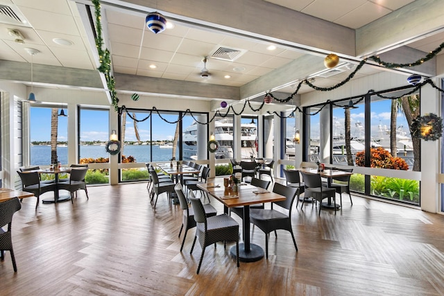 dining space with a water view and hardwood / wood-style flooring