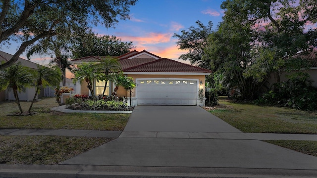 mediterranean / spanish-style home with a garage and a lawn