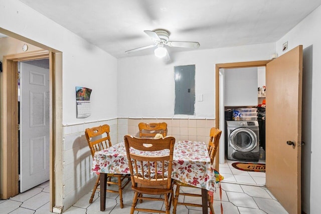 dining room with ceiling fan, washer / dryer, tile walls, and electric panel