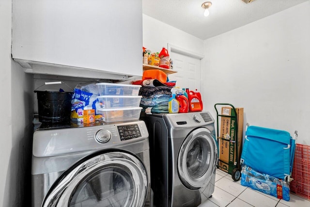 clothes washing area featuring light tile patterned floors, cabinets, a textured ceiling, and independent washer and dryer