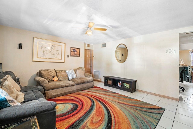 living room featuring ceiling fan, light tile patterned floors, and a textured ceiling