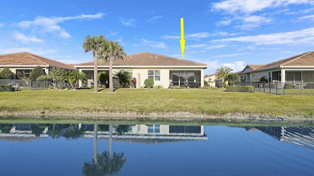 back of house with a yard, a water view, fence, and a sunroom