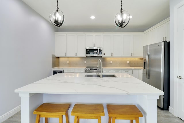 kitchen with appliances with stainless steel finishes, a kitchen bar, a sink, and tasteful backsplash