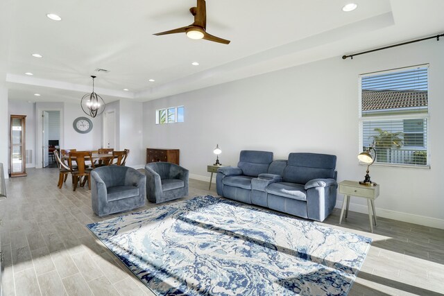 living room featuring light wood-type flooring, a water view, and ceiling fan