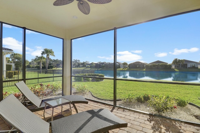 unfurnished sunroom featuring a water view and ceiling fan