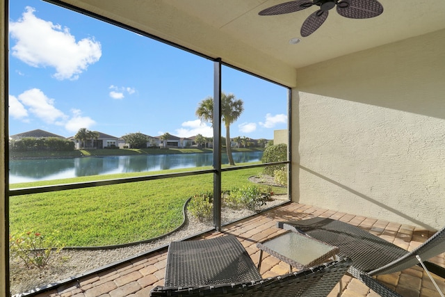 sunroom / solarium with a water view and ceiling fan