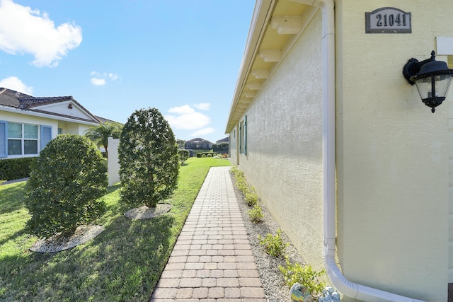 view of side of home with a yard and stucco siding