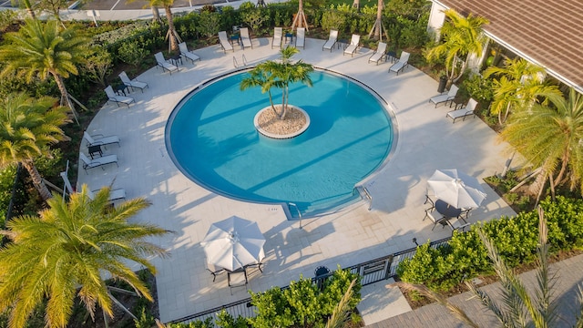 community pool with fence and a patio