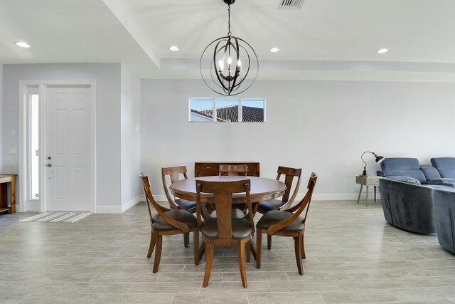 dining space with ceiling fan with notable chandelier, a tray ceiling, and a water view