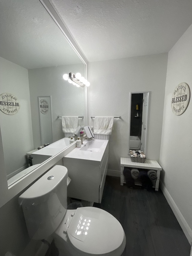 bathroom featuring toilet, vanity, a textured ceiling, and hardwood / wood-style flooring