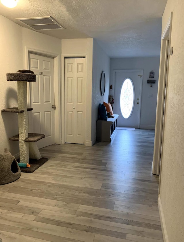 entryway featuring hardwood / wood-style floors and a textured ceiling