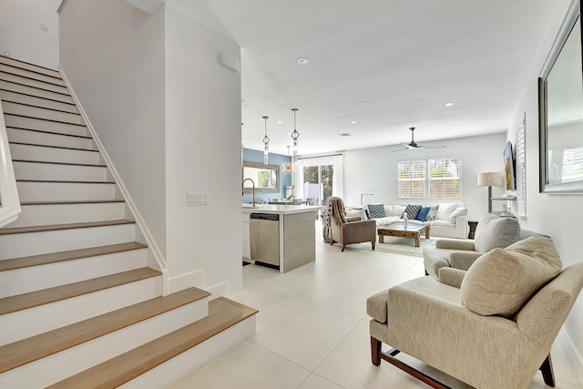 tiled living room featuring ceiling fan and sink