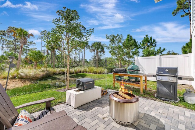 view of patio / terrace with a fire pit and a grill