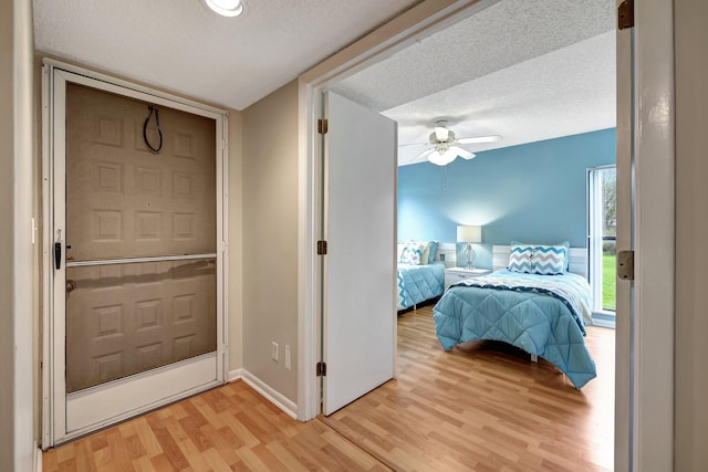 entrance foyer with ceiling fan, light wood-type flooring, and a textured ceiling