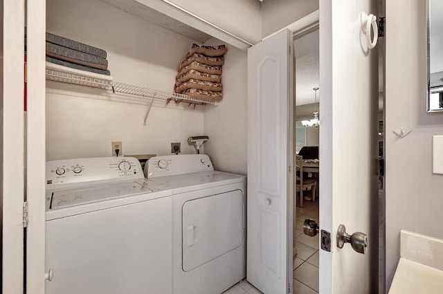 laundry area with independent washer and dryer, a notable chandelier, and light tile patterned flooring