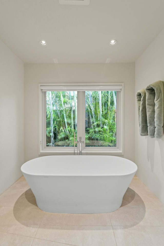 bathroom featuring a bathtub, tile patterned floors, and plenty of natural light