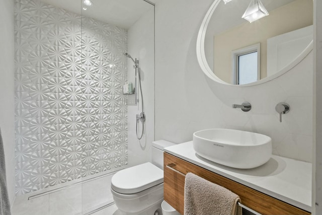 bathroom with vanity, a shower, tile walls, tile patterned flooring, and toilet