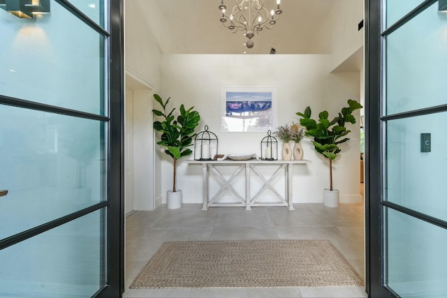 bathroom with a towering ceiling, concrete floors, and an inviting chandelier