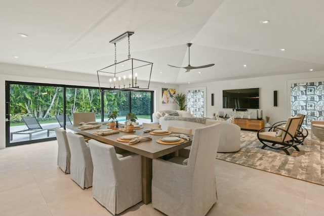 tiled dining space with ceiling fan with notable chandelier and lofted ceiling