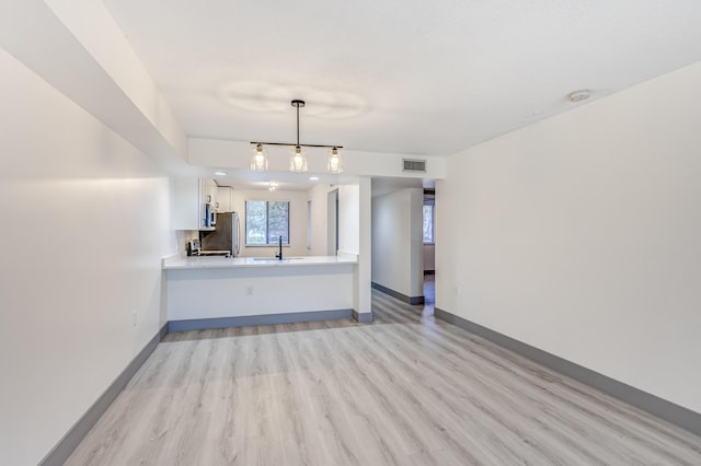 unfurnished living room featuring light hardwood / wood-style flooring and sink