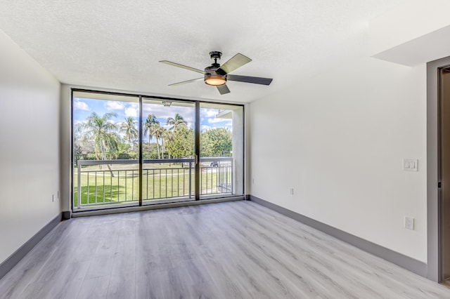 spare room featuring a textured ceiling, light hardwood / wood-style floors, ceiling fan, and a healthy amount of sunlight