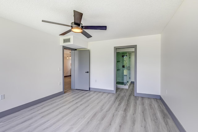 unfurnished bedroom with ensuite bathroom, ceiling fan, light hardwood / wood-style floors, and a textured ceiling