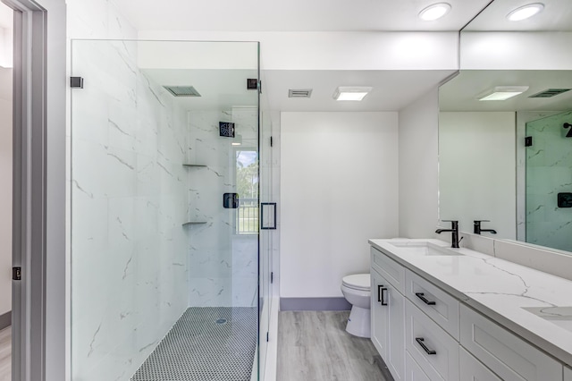 bathroom with vanity, hardwood / wood-style flooring, toilet, and walk in shower