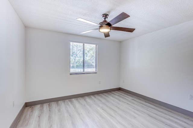 spare room with ceiling fan, light wood-type flooring, and a textured ceiling