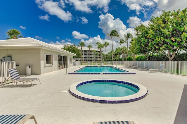 view of pool featuring a hot tub and a patio area