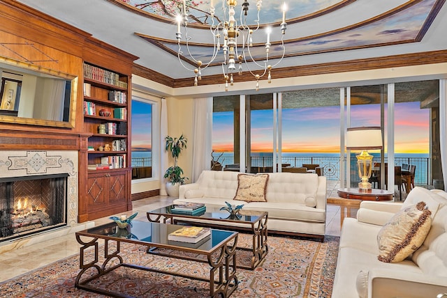 5310 N Ocean Dr Unit Ph-1201, Singer Island, FL 33404 - living area featuring a fireplace, ornamental molding, a water view, a raised ceiling, and a notable chandelier
