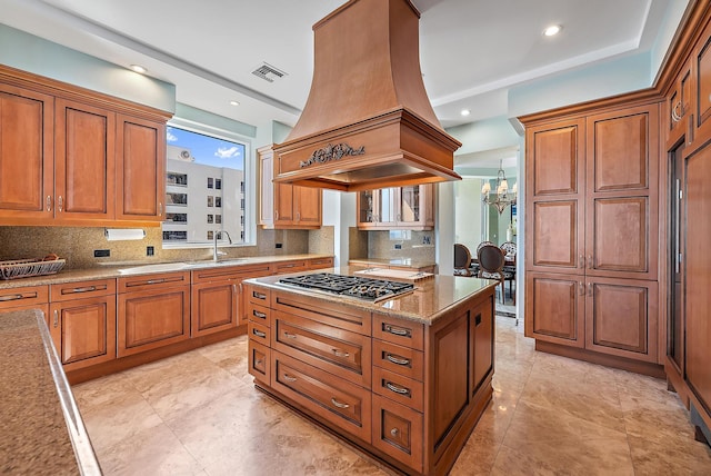 5310 N Ocean Dr Unit Ph-1201, Singer Island, FL 33404 - kitchen with visible vents, island exhaust hood, a sink, an inviting chandelier, and stainless steel gas cooktop