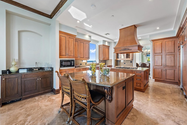5310 N Ocean Dr Unit Ph-1201, Singer Island, FL 33404 - kitchen with island exhaust hood, dark stone countertops, a sink, a kitchen island, and black microwave