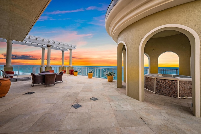 5310 N Ocean Dr Unit Ph-1201, Singer Island, FL 33404 - patio terrace at dusk featuring a pergola, outdoor dining area, and a water view