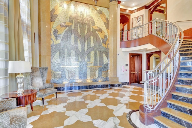 5310 N Ocean Dr Unit Ph-1201, Singer Island, FL 33404 - entrance foyer featuring crown molding, stairs, a towering ceiling, and decorative columns