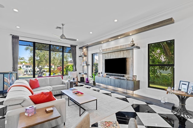 living room with hardwood / wood-style flooring, ceiling fan, and ornamental molding