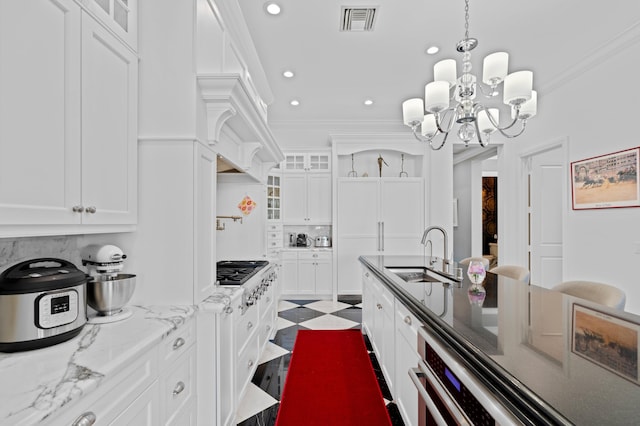 kitchen with a breakfast bar, white cabinets, sink, ornamental molding, and light stone counters