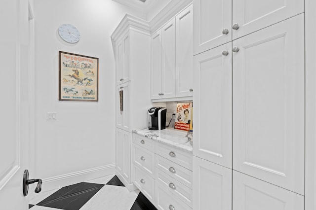 interior space featuring light tile patterned floors and crown molding